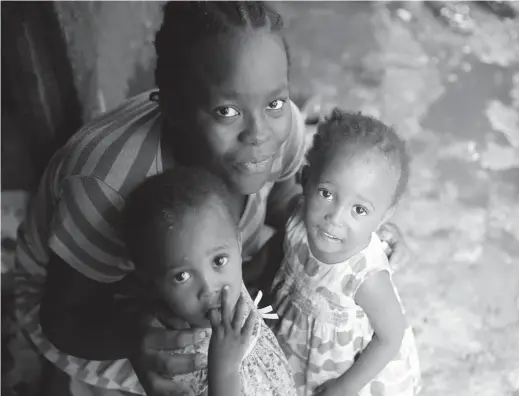  ??  ?? Twenty-year-old Fatmata poses with her twin daughters in Susan’s Bay, Sierra Leone. — Reuters