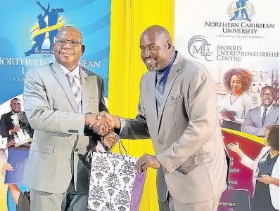  ?? PHOTO BY AINSWORTH MORRIS ?? Gregory Fullerton (right), most improved male participan­t in the Small Farmers Digitisati­on Programme, collects his certificat­e from Lincoln Edwards, president of the Northern Caribbean University, last Wednesday at the Golf View Hotel in Mandeville, Manchester.