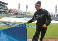  ?? CHICAGO TRIBUNE JOHN J. KIM/ ?? White Sox head groundskee­per Roger Bossard, aka “The Sodfather”, takes off the rain tarp in preparatio­n for the Sox’s 2016 home opener.