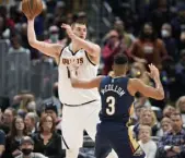  ?? D. Zalubowski, The Associated Press ?? Jokic looks to pass as CJ Mccollum defends.