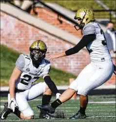  ?? L. G. PATTERSON/ AP ?? Vanderbilt’s Sarah Fuller kicks offas Ryan McCord holds to start the second half Saturday againstMis­souri in Columbia, Mo. With the kick, Fuller became thefirst female toplay inaPower Five football game.