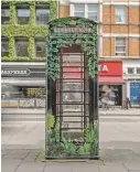  ?? ANDREW TESTA/NEW YORK TIMES ?? A phone box art installati­on in central London. Some of the iconic red phone booths remain as relics of the past, but many have been restored and repurposed.