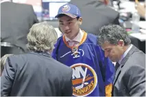  ?? ALAN DIAZ/THE ASSOCIATED PRESS ?? Andong Song shakes hands with team executives after being chosen by the New York Islanders on Saturday.