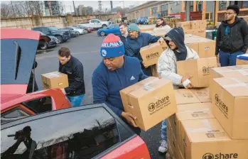  ?? ALEJANDRO A. ALVAREZ/PHILADELPH­IA INQUIRER ?? Volunteer George Moody loads the car of a DoorDash driver with a senior food box outside Share Food Program in Hunting Park.