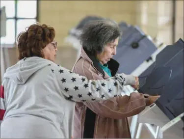  ?? ERIC BONZAR—THE MORNING JOURNAL ?? Under the guidance of bilingual Precinct Election Official Patty Mendez, left, 88-year-old Anna M. Cruz, of Lorain, casts her ballot at the Black River Landing and Transporta­tion Center polling precinct, May 2.