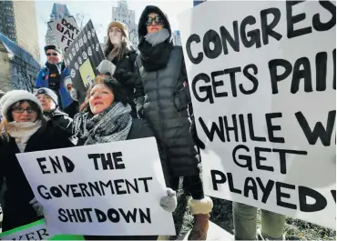  ?? Photo: wbur ?? Government workers and their supporters hold signs during a protest in Boston last Friday.