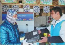  ?? PROVIDED TO CHINA DAILY ?? Yang Tao, a courier at the delivery office at the foot of Mount Qomolangma, hands a parcel to a customer on Nov 4.