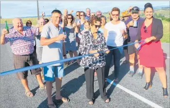  ?? PICTURE / FRANCIS MALLEY ?? Faye Irwin Erceg cut a ribbon to unofficial­ly declare the newly sealed Upper Okahu Rd open.