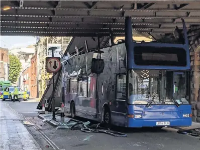  ??  ?? The roof of a bus was torn off when it became stuck under a bridge on Frogmore Street last week