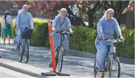  ?? JACQUES NADEAU LE DEVOIR ?? À Saint-Hilaire, sur la Rive-Sud de Montréal, trois religieuse­s circulent sur la piste cyclable. Dans les banlieues, l’utilisatio­n du vélo n’est plus que récréative, mais aussi utilitaire.