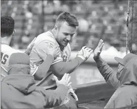  ?? Elaine Thompson Associated Press ?? MIKE TROUT IS GREETED in the dugout after his two-run home in the first inning against Seattle. Trout has been making more hard contact this season.
