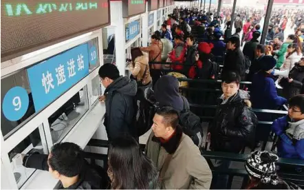  ??  ?? Rushing back home: Travellers queuing outside a train station in Beijing yesterday. — AFP