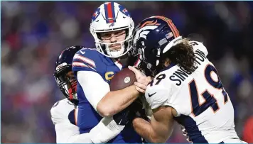  ?? ?? (AP Photo/Adrian Kraus) Denver Broncos' Baron Browning, left, and Alex Singleton (49) tackle Buffalo Bills quarterbac­k Josh Allen, center, during the first half Monday.