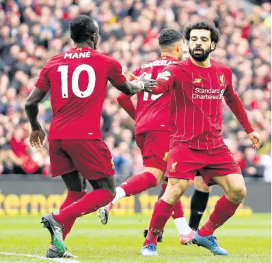  ?? AP PHOTOS ?? Liverpool’s Mohamed Salah (right) celebrates with teammate Sadio Mane after scoring his side’s opening goal during the English Premier League match against Bournemout­h at Anfield Stadium in Liverpool, England, on Saturday, March 7.