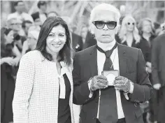  ??  ?? Hidalgo awards the Grand Vermeil De La Ville De Paris medal to Lagerfeld after Chanel 2017-2018 autumn/winter Haute Couture collection show in Paris on Tuesday. (Right) Models present creations for Chanel under a replica of the Eiffel Tower at the...