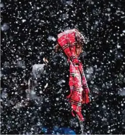  ?? - AP ?? PHILADELPH­IA: In this Friday, March 10, 2017 file photo, a woman walks through in a winter snow storm in Philadelph­ia.