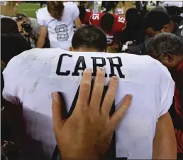  ?? Bay Area News Group/ TNS ?? San Francisco 49ers’ Bradley Pinion places his hand on the back of Oakland starting quarterbac­k Derek Carr as they pray after their NFL game at Levi’s Stadium in Santa Clara on Nov. 1.