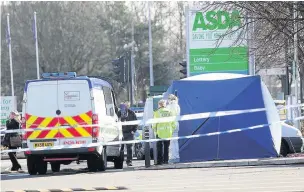  ??  ?? ●●Police examine the fire damaged van on the Asda car park in Reddish