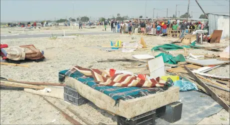  ?? Picture: BHEKI RADEBE ?? HOPELESS: Distressed residents watch as their shacks are demolished in Mfuleni. Some of them said they had no money to pay rent.