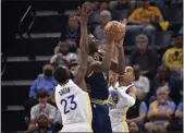  ?? BRANDON DILL — THE ASSOCIATED PRESS ?? Grizzlies forward Jaren Jackson Jr. (13) shoots from between Warriors forward Draymond Green (23) and guard Jordan Poole (3) during the first half of Game 2of a second-round playoff series on Tuesday.