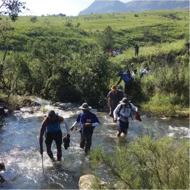  ?? PICTURES: KEVIN RITCHIE ?? CROSSINGS: Trek4Mande­la hikers ford a mountain stream in the central Drakensber­g.