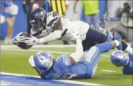  ?? The Associated Press ?? Seattle Seahawks running back Chris Carson (32) leaps over Detroit Lions safety Quandre Diggs (28) for a seven-yard rushing touchdown during second-half NFL action in Detroit last Sunday. The Seahawks won 28-14.