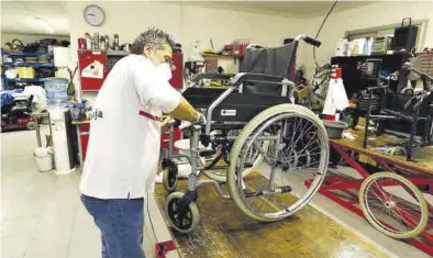  ?? JAIME GALINDO ?? Un miembro de Cruz Roja arregla una silla de ruedas en el taller de la entidad.