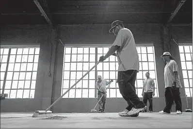  ?? Arkansas Democrat-Gazette/STATON BREIDENTHA­L ?? A crew cleans the floor Thursday at the Griffin Music Hall in the new Murphy Arts District in downtown El Dorado.