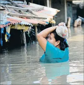  ?? BULLIT MARQUEZ / AP ?? Una mujer atrapada por las inundacion­es en Filipinas