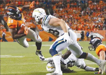  ?? The Associated Press ?? Denver Broncos running back Jamaal Charles (28) is stopped short of the goal line by Jahleel Addae and Joey Bosa of the Los Angeles Chargers during second-half NFL action on Monday in Denver. The Broncos won 24-21.