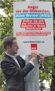  ?? FOTO: MARTIN HENNINGS ?? Der Kandidat legt selbst Hand an: Leon Hahn platziert eines der AfD-kritischen Plakate beim Stadtbahnh­of.