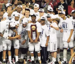  ?? Mark Humphrey / Associated Press ?? UConn players celebrate with the trophy after the NCAA Tournament championsh­ip game against Butler on April 4, 2011.