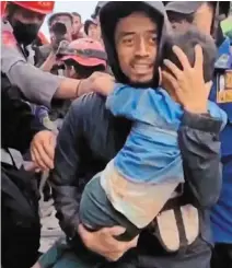  ?? —AFP ?? Miracle boy: This screengrab from mobile phone video footage shows Azka being pulled out of the rubble in Cianjur.