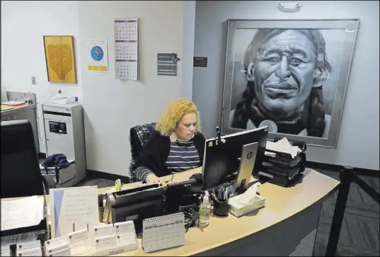  ?? Ted S. Warren The Associated Press ?? Nia Tagoai, a patient scheduler at a clinic offering health care and other services operated by the Seattle Indian Health Board, works at her desk Friday in Seattle. The board plans to cut services if the partial government shutdown continues much longer.