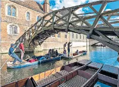  ??  ?? Getting ahead: students pass under Cambridge’s Mathematic­al Bridge, designed in 1748