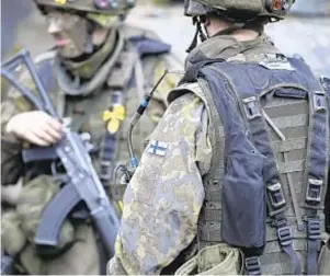  ?? AP ?? Top, Russia-aligned troops work in wreckage of theater in devastated Mariupol, Ukraine. Above, Finnish soldiers trained in western Finland as neutral nation moved closer to applying for NATO membership in the wake of Russian invasion of Ukraine.