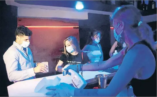  ?? ACN / ELOI TOST ?? Una camarera de la discoteca Totem de Tarragona desinfecta­ndo la barra del local