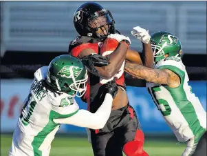  ?? CP PHOTO ?? Ottawa Redblacks’ Dominique Rhymes (centre) fends off Saskatchew­an Roughrider­s’ Ed Gainey (left) and Kacy Rodgers II during second half Eastern semifinal CFL action in Ottawa on Sunday.