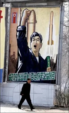  ?? AP/NG HAN GUAN ?? A man walks past a propaganda billboard in Pyongyang, North Korea, Friday, April 13. The slogan reads “Let’s raise the spirits of winners and build a strong and prosperous nation!”