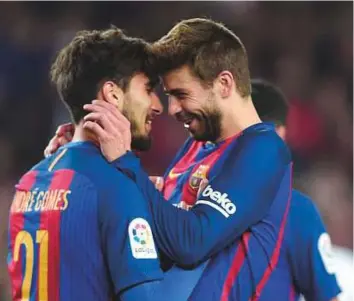  ?? AFP ?? Barcelona midfielder Andre Gomes (left) celebrates with defender Gerard Pique after scoring during the 4-2 league win against Valencia on Sunday. Pique has told fans not to boo Gomes.