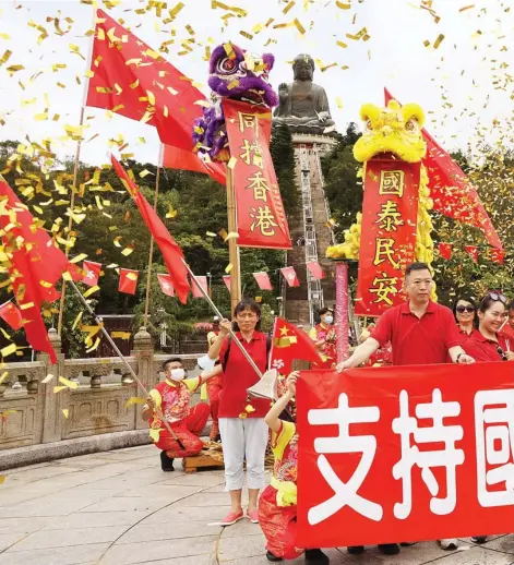  ??  ?? Hong Kong residents perform a lion dance to celebrate the 23rd anniversar­y of Hong Kong’s return to the motherland and the promulgati­on of the n