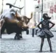  ??  ?? The Charging Bull and Fearless Girl statues face each other on Lower Broadway in New York.