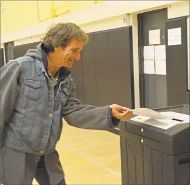  ?? Cassandra Day / Hearst Connecticu­t Media / ?? Fred Carroll feeds his ballot into the tabulator Tuesday afternoon at Woodrow Wilson Middle School. Middletown voters went to the polls to choose representa­tives for the Board of Education and Planning and Zoning and cast their vote on the new middle...