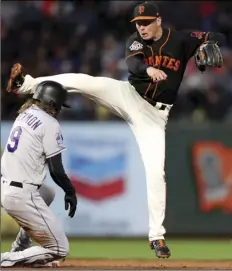  ?? AP PHOTO/SCOT TUCKER ?? San Francisco Giants second baseman Joe Panik (12) forces out Colorado Rockies center fielder Charlie Blackmon (19) and completes a double play in the fourth inning of a baseball game in San Francisco, on Saturday.