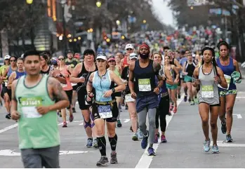  ?? Elizabeth Conley photos / Houston Chronicle ?? Runners take off under cloudy skies Sunday in the 45th annual Chevron Houston Marathon.
