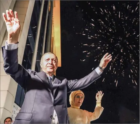  ?? TURKISH PRESIDENTI­AL PRESS SERVICE/KAYHAN OZER/AFP ?? Turkish President Recep Tayyip Erdogan and his wife, Emine, greet supporters from a balcony at the headquarte­rs of the AK Party in Ankara, on Sunday evening as they celebrate his winning five more years in office with sweeping new powers after a decisive election victory. A night of triumph for Erdogan saw the man who has dominated Turkey for the past 15 years declared winner of the presidenti­al poll without needing a second round of voting. He also led his ruling alliance to an overall majority in parliament.