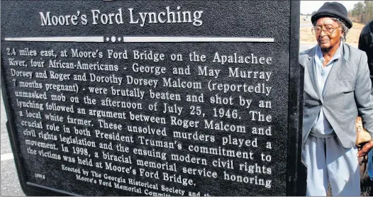  ?? AP FILE PHOTO ?? In 2005,Rosa Ingram, Roger Malcom’s aunt, reads the Georgia Historical Society marker for the Moore’s Ford bridge lynching, outside Monroe, Ga.