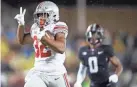  ?? KYLE ROBERTSON/COLUMBUS DISPATCH ?? Freshman RB Treveyon Henderson showed his speed and elusivenes­s with a 70-yard touchdown reception.