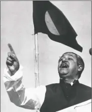  ??  ?? Sheikh Mujibur Rahman, East Pakistan’s Awami League party leader, addresses a mass gathering March 7, 1971, beneath the flag proposed for for a new country. At the time this photo was taken, the government in the Bengali-speaking Eastern province of Pakistan was running on an informal basis under Rahman’s leadership. On the day Rahman declared: “The struggle this time is for emancipati­on! The struggle this time is for independen­ce!”