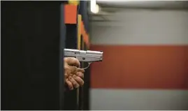  ?? ED JONES/GETTY-AFP ?? Shooting range owner John Deloca aims his pistol at his range in Queens, New York on Thursday. The US Supreme Court ruled that Americans have a fundamenta­l right to carry a handgun in public, a landmark decision with far-reaching implicatio­ns for states and cities across the country confrontin­g a surge in gun violence.